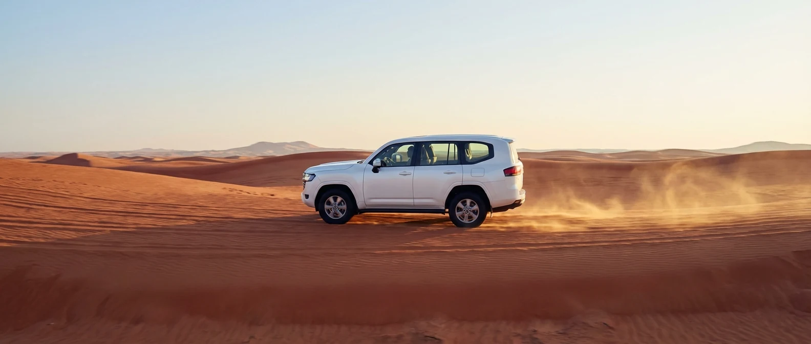 White 2025 Toyota Land Cruiser crossing Dubai red dunes in a morning desert safari