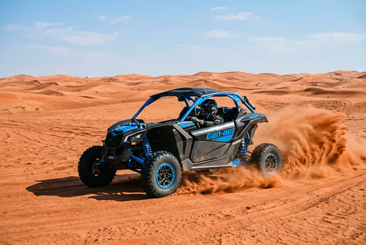 Can-Am Maverick X3 kicking up dust while driving across open desert terrain in Dubai