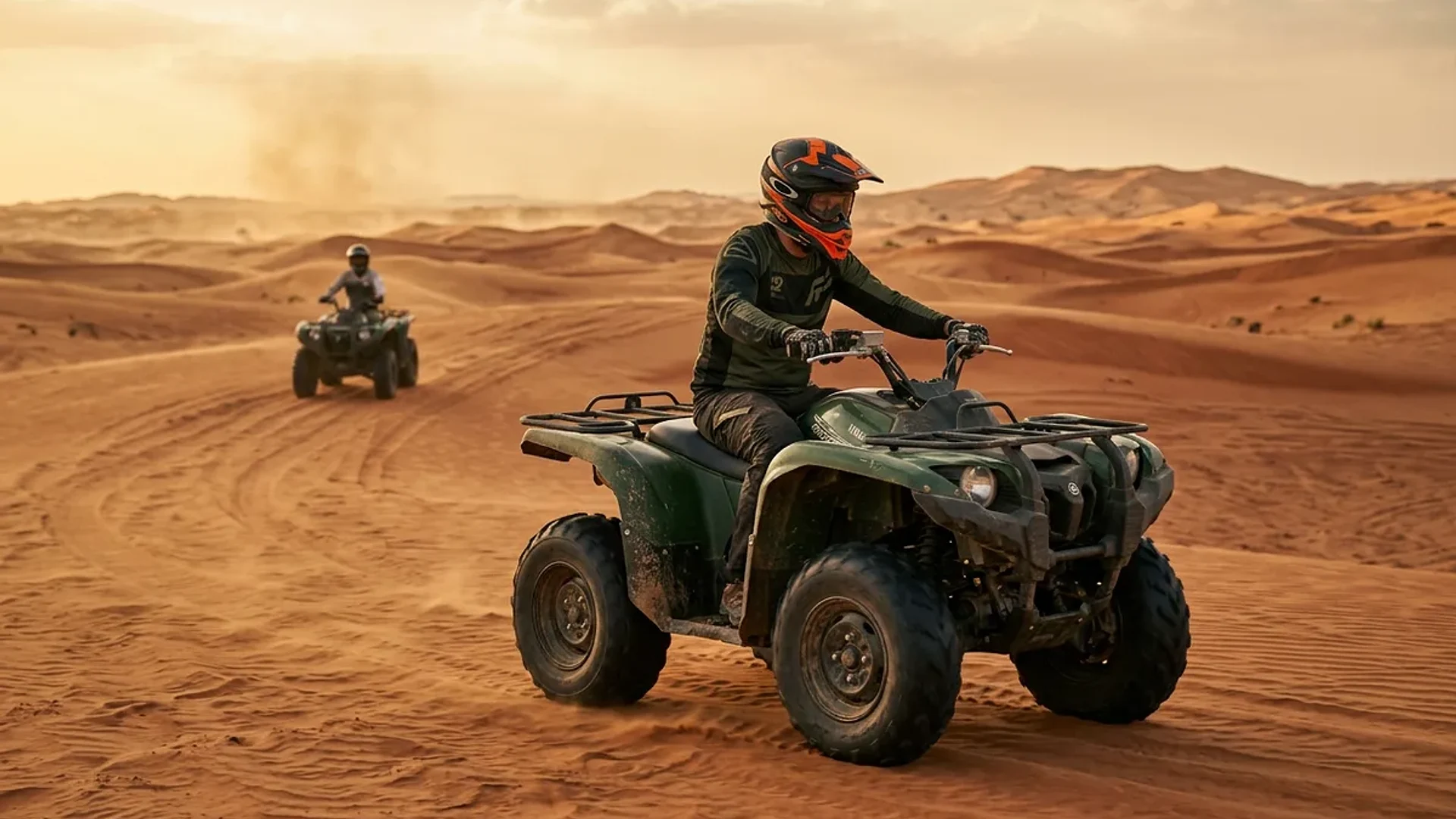 Yamaha Grizzly quad bike parked on a red dune at sunset near a desert camp, Dubai